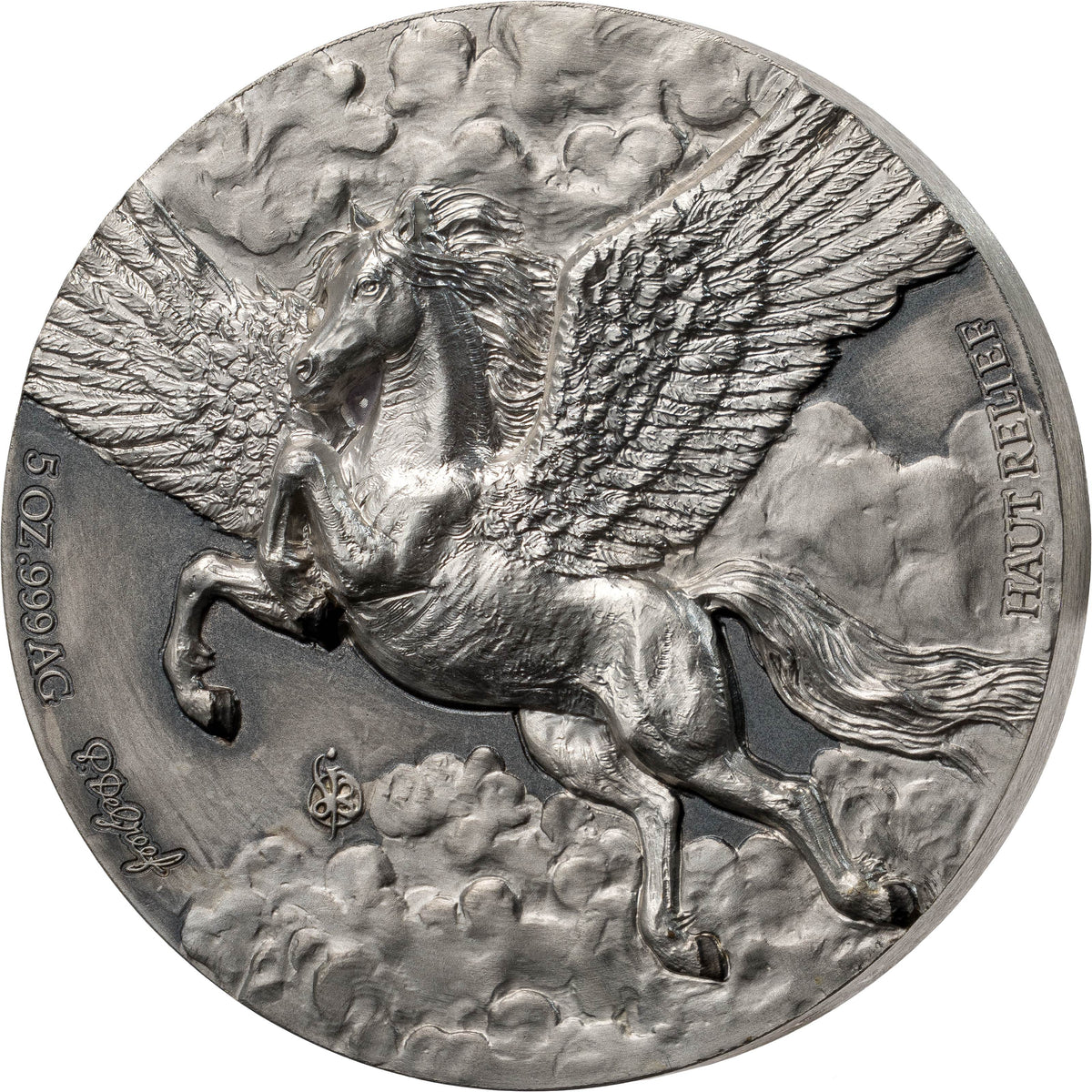 A circular silver-toned medallion or coin featuring a detailed relief of a winged horse, likely Pegasus, galloping through clouds. The coin has raised text reading 'HAUT-CLASSE' and '5 02 1990 AG' along with a signature near the lower left edge, shown on a plain white background.