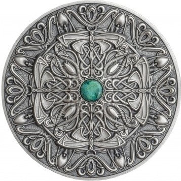 A circular 3oz silver coin with an intricate Art Nouveau Mandala design and a green gemstone in the center.