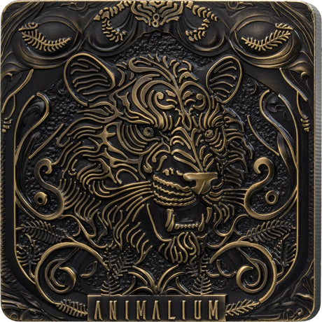 A square decorative plaque or box cover featuring an ornate embossed animal head with swirling floral and scroll motifs, in dark metallic black and antique gold tones. The word 'ANIMALIUM' appears at the bottom.