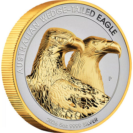 A round Australian gold wedge-tailed eagle coin featuring two detailed eagle heads in polished gold on a silver-toned center, with a ribbed gold outer rim. The text reads 'AUSTRALIAN WEDGE-TAILED EAGLE' and '2026 5oz 9999 SILVER'.