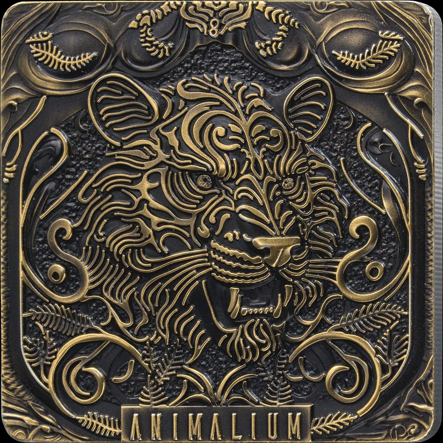 A square decorative plaque or box cover featuring an ornate embossed animal head design in metallic gold and dark bronze tones, with the word 'ANIMALIUM' at the bottom.