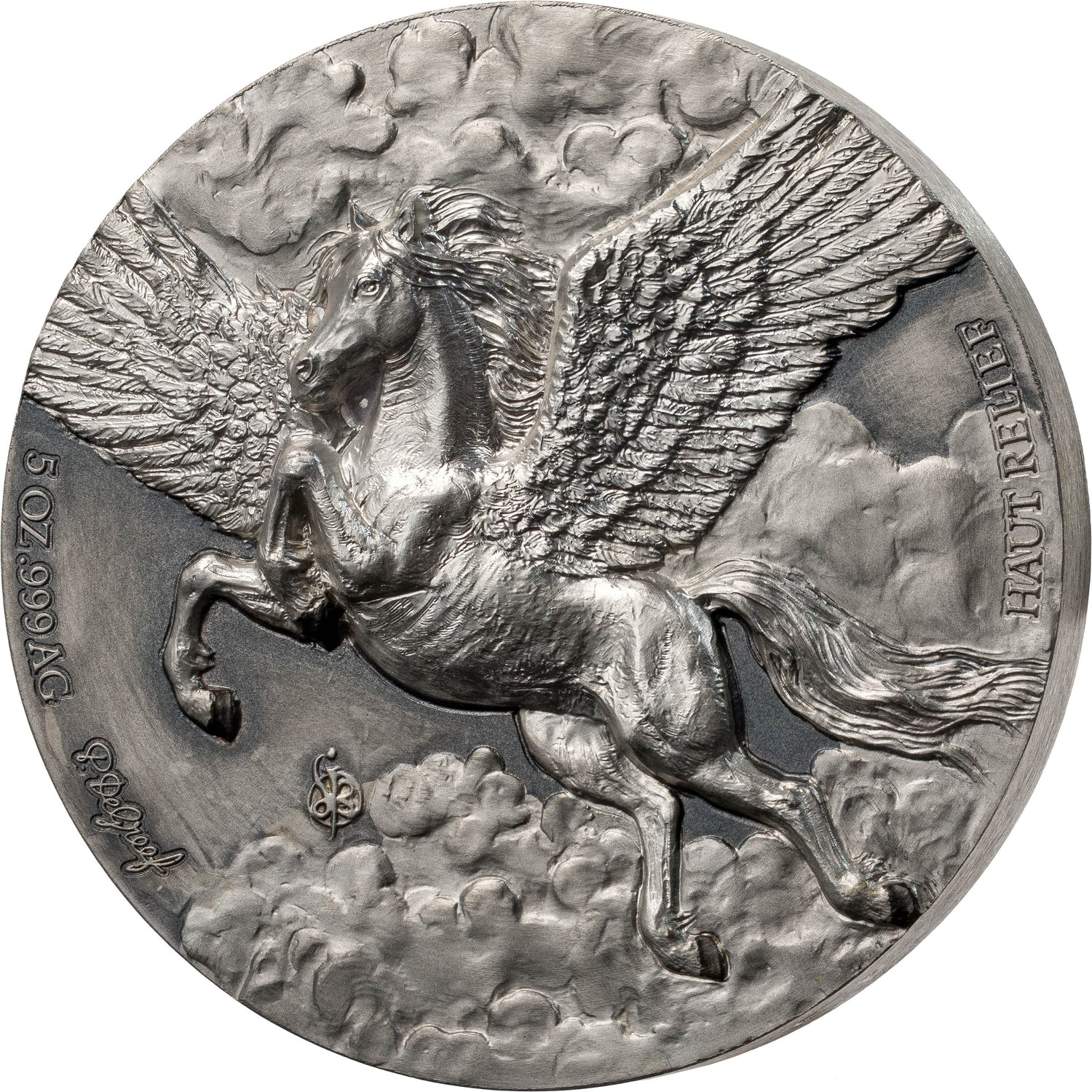 A circular silver-toned medallion or coin featuring a detailed relief of a winged horse, likely Pegasus, galloping through clouds. The coin has raised text reading 'HAUT-CLASSE' and '5 02 1990 AG' along with a signature near the lower left edge, shown on a plain white background.