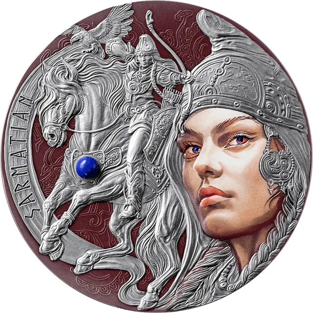 A circular silver-toned medallion or coin featuring a sculpted warrior on a horse with a winged motif, alongside a large stylized female face in profile. The design includes embossed details, engraved text along the left edge, and a small blue gemstone accent on the horse.
