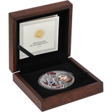 An open dark wood presentation box with a black velvet insert holding a round silver coin featuring a woman's face and a horse, alongside a Certificate of Authenticity card inside the lid.