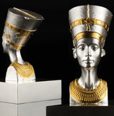 A 3D shaped silver coin with gold gilding, depicting the bust of Nefertiti. The coin is displayed on a stand against a black background.
