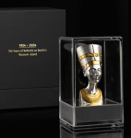 Box and Display case for Bust of Nefertiti , a 3D shaped silver coin with gold gilding, depicting the bust of Nefertiti. The coin is displayed on a stand against a black background. 