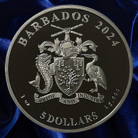Coat of arms on blue satin: 2024 Barbados $5 silver coin showing the coat of arms and Ag .999 inscription, against blue satin.