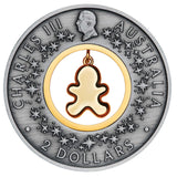 Obverse of the 2026 Gingerbread Christmas $2 silver coin, featuring King Charles III, decorative stars and the back of the dangling gingerbread insert.