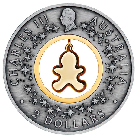 Obverse of the 2026 Gingerbread Christmas $2 silver coin, featuring King Charles III, decorative stars and the back of the dangling gingerbread insert.