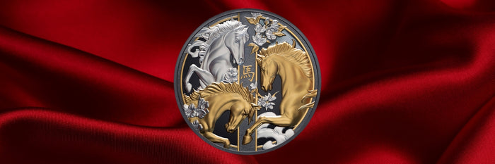 A circular collectible coin featuring two horses facing each other, one in gold and one in silver, set against a red satin fabric background.