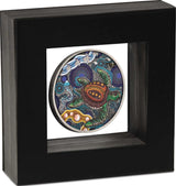 A square black shadow box display frame showcasing a circular silver coin  suspended in a latex floating frame with a colorful, detailed sea turtle illustration on a white background insert.