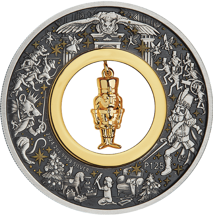 A silver coin with a Christmas-themed design featuring a gold-plated nutcracker figurine at its center, surrounded by stars and other festive imagery.