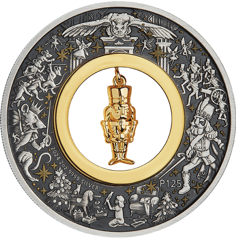 A silver coin with a Christmas-themed design featuring a gold-plated nutcracker figurine at its center, surrounded by stars and other festive imagery.