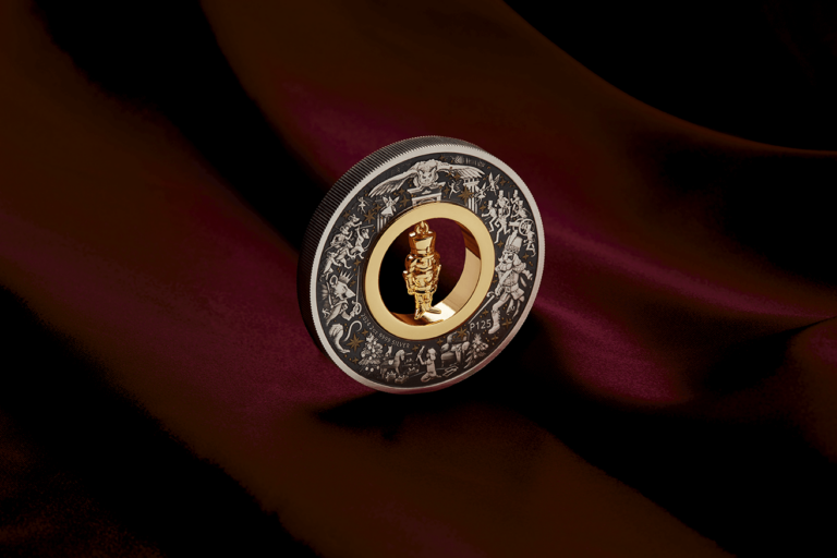 Christmas Nutcracker silver coin viewed from the opposite angle on burgundy fabric