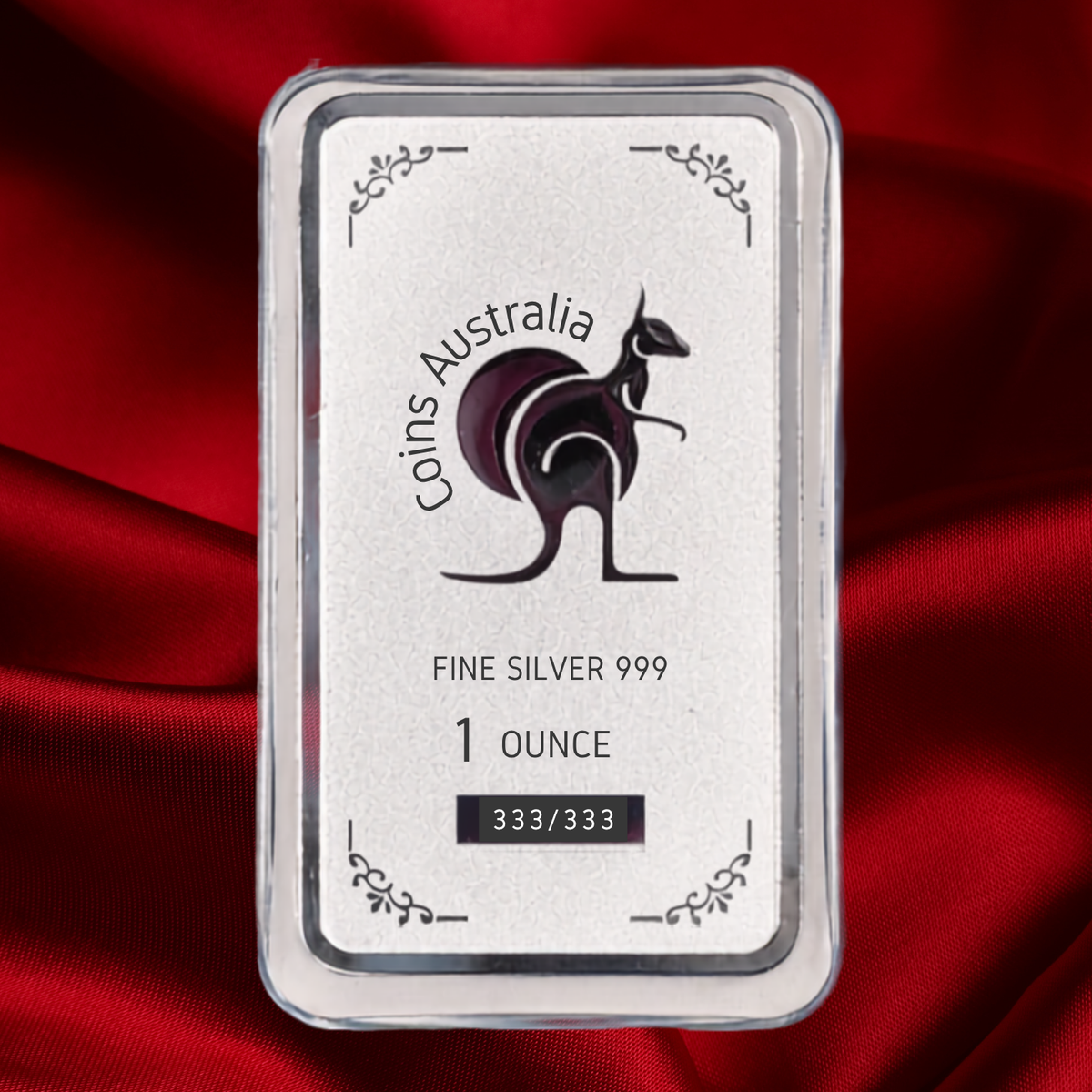 A 1-ounce silver bar from Coins Australia, featuring a kangaroo logo and 'FINE SILVER 999' text, presented in a clear protective case over a draped red satin fabric background.