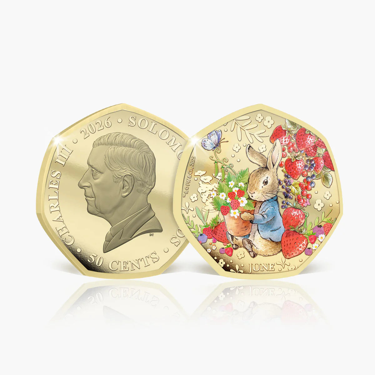 Two gold-colored hexagonal Solomon Islands 50 cents coins shown on a light gray background with a reflection below. One coin features a profile of Charles II, and the other is decorated with Peter Rabbit, strawberries, flowers, and a butterfly.