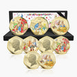 A set of eight gold-plated Peter Rabbit coin medallions displayed in front of their open black presentation box on a white background.