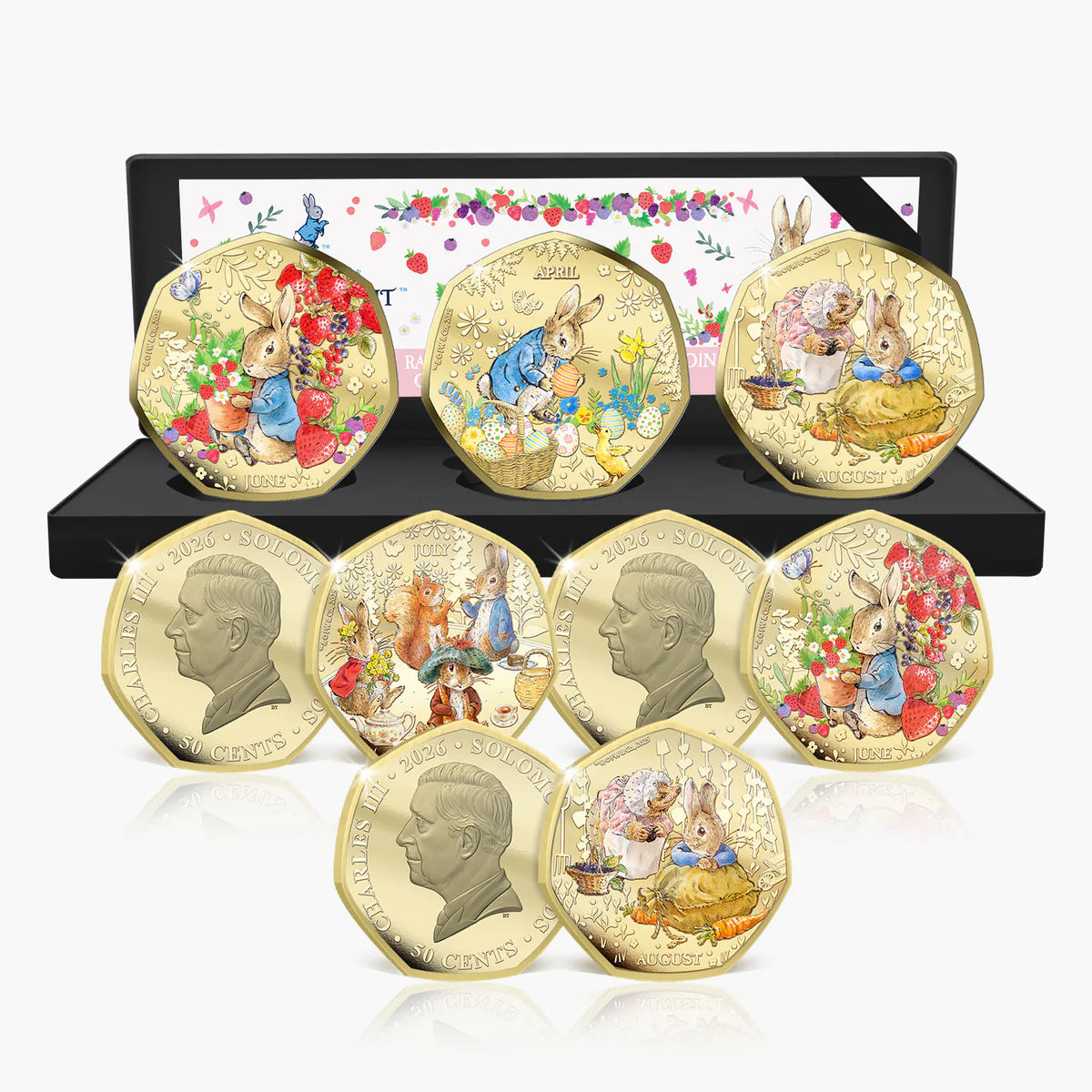 A set of eight gold-plated Peter Rabbit coin medallions displayed in front of their open black presentation box on a white background.
