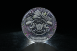 Decorative coin with intricate design on a dark background