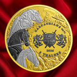 A round commemorative coin with a gold-toned outer ring and a detailed central design featuring horses, a shield, lions, and the text 'GARPATIAN'S MUT 2026 5 THEALERS', shown against a red satin fabric background.