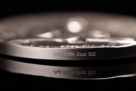 Close-up of a silver ring with engraved text on a black background