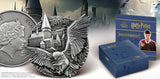 Harry Potter-themed silver coin, box, and book with castle and owl design.