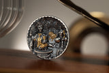 Decorative coin with intricate design on a wooden surface
