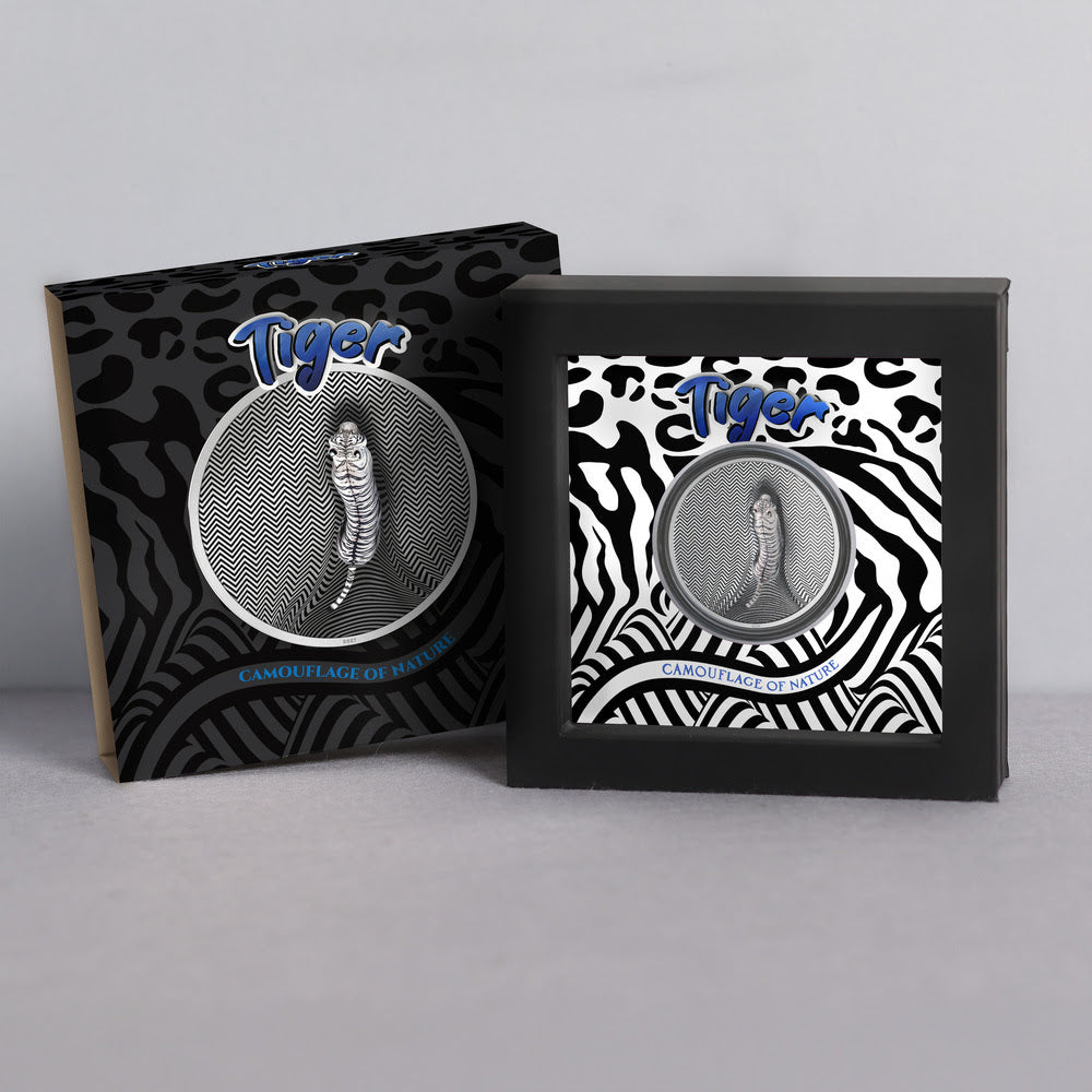 Tiger Camouflage of Nature silver coin in a black presentation stand beside its tiger-patterned outer packaging.