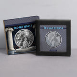 A framed and boxed collectible featuring a circular silver-toned relief of the Trojan Horse, shown with its illustrated outer box on a light gray studio background.