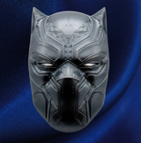 A metallic black panther mask with intricate geometric engravings, displayed against a dark blue satin fabric background.
