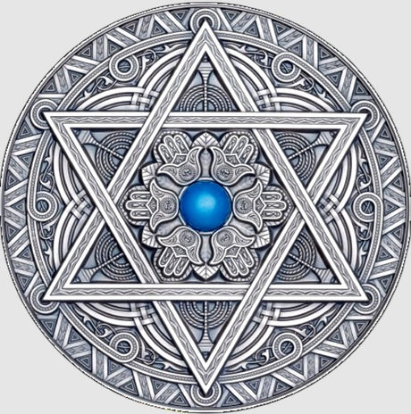 A detailed silver coin with a mandala design featuring a central blue gemstone, surrounding by intricate geometric patterns and the star of David.