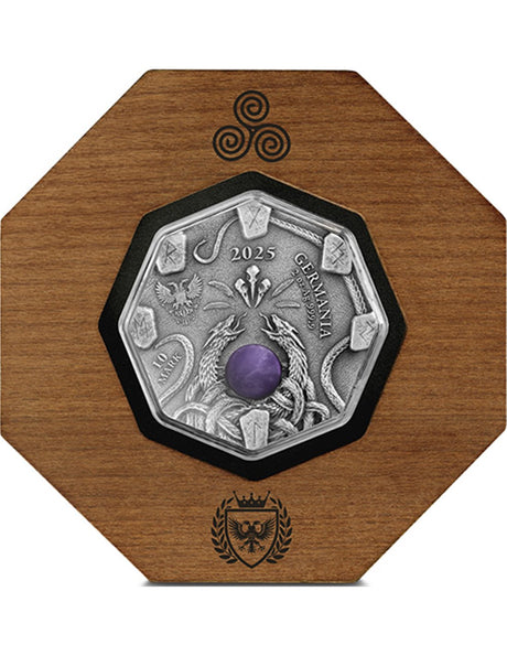 Silver coin with purple gemstone on a wooden display stand with decorative emblem