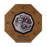Silver coin with a wooden frame featuring engraved designs and text.
