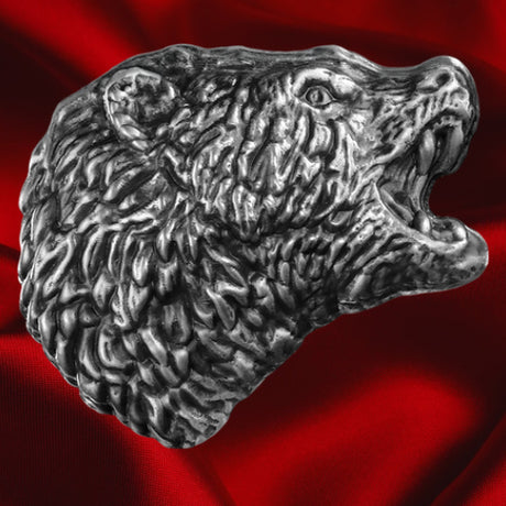 Front view on red satin: Germania Mint 2025 Bearlin 5oz silver cast bar shaped as a roaring bear’s head, with textured fur, bared teeth and an antiqued finish, against red satin.