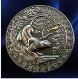 A round metallic medallion or coin featuring an embossed animal and floral design, with a small gold accent near the top right, shown against a dark blue satin-like background.