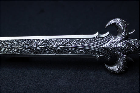 Close-up of the Sword of Chiwoo blade and curved guard, highlighting raised ornamental patterns and the antique silver finish.