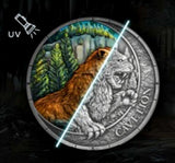 Coin with a lion design, featuring UV text and forest scene, on a dark background.