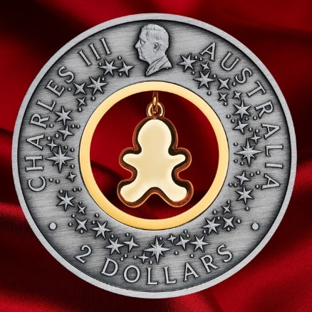 Obverse of the 2026 Gingerbread Christmas $2 silver coin, featuring King Charles III, decorative stars and the back of the dangling gingerbread insert.