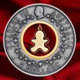 Obverse of the 2026 Gingerbread Christmas $2 silver coin, featuring King Charles III, decorative stars and the back of the dangling gingerbread insert.