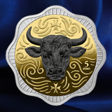 A 5 Euro coin featuring a detailed black bull head on a gold background with decorative swirls and a silver-toned scalloped border, set against a dark blue satin fabric backdrop.