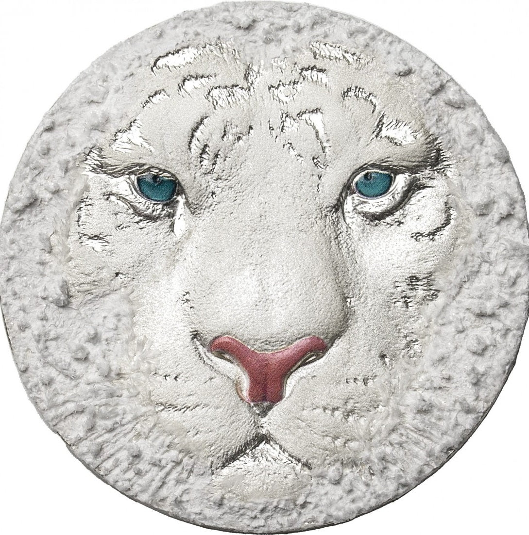 A silver coin with a high relief design depicting the head of a white tiger.