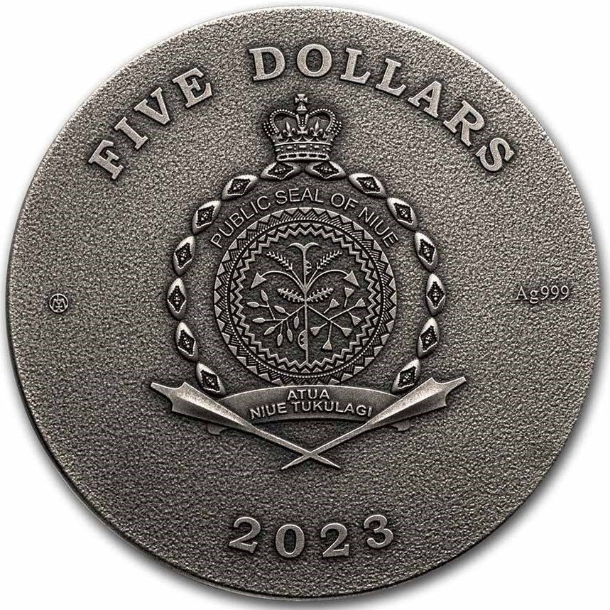 A close-up view of the all-silver obverse face of the 2023 Niue $5 "Lady Flame" coin. The coin is finished in a weathered, antiqued silver style with no colour. Placed in the dead center is the official Public Seal of Niue. The outer ring of the coin is densely filled with crisply engraved ancient Egyptian hieroglyphic symbols, forming a framing pattern around the legal tender inscriptions.