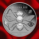 Reverse, red background: 2026 Lucifer Bee 2 oz Black Proof silver coin showing the bee, anatomical studies and Specimen 01 inscription on red satin.