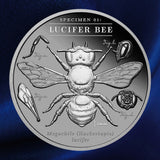 Reverse, blue background: 2026 Lucifer Bee 2 oz Black Proof silver coin showing the bee and scientific-study details on blue satin.