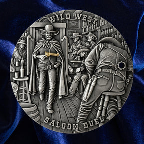 A circular silver-toned metal medallion featuring a detailed Wild West saloon duel scene, displayed against a dark blue satin fabric background.