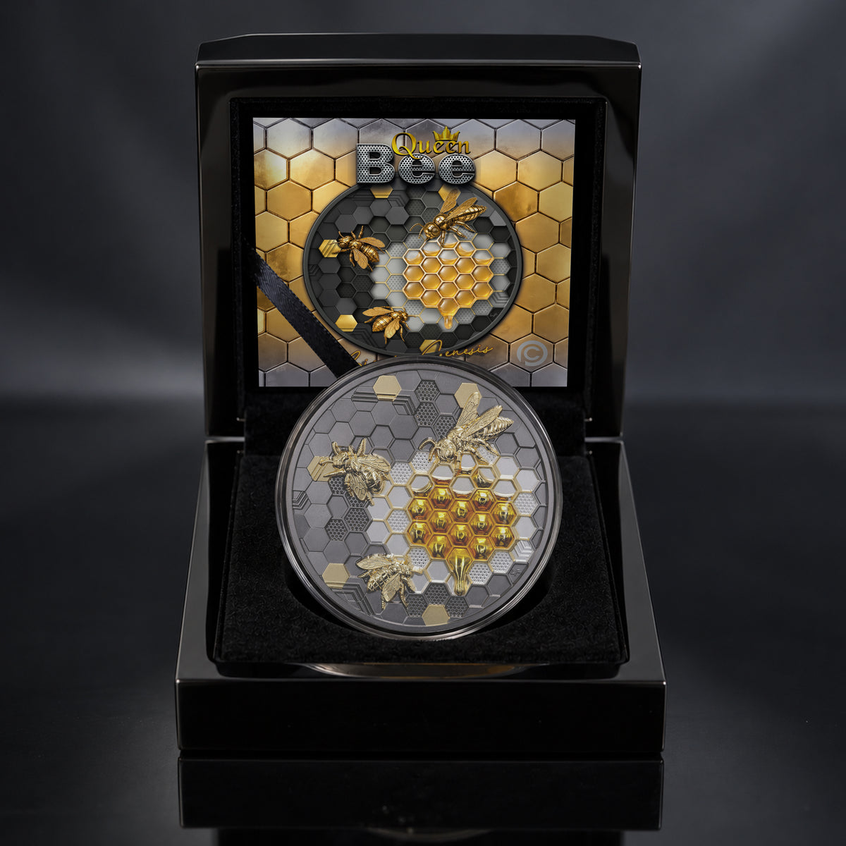 A round collectible coin featuring gold and silver bee and honeycomb designs, displayed inside an open black presentation case with a printed certificate of Authenticity.