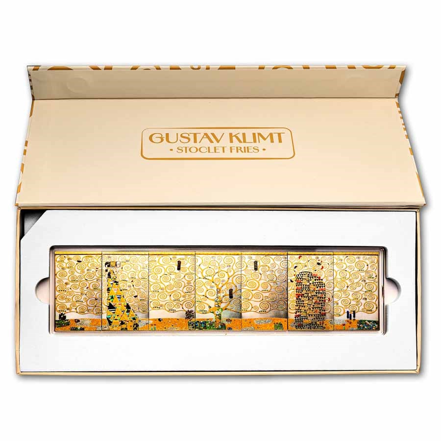 A Gustav Klimt 'Stoclet Fries' gift set containing six rectangular glass plates with gold-toned Art Nouveau designs, presented in a white and beige box with the brand name 'GUSTAV KLIMT' printed on the inside lid.