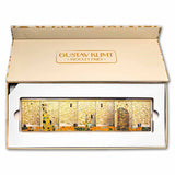 A Gustav Klimt 'Stoclet Fries' gift set containing six rectangular glass plates with gold-toned Art Nouveau designs, presented in a white and beige box with the brand name 'GUSTAV KLIMT' printed on the inside lid.