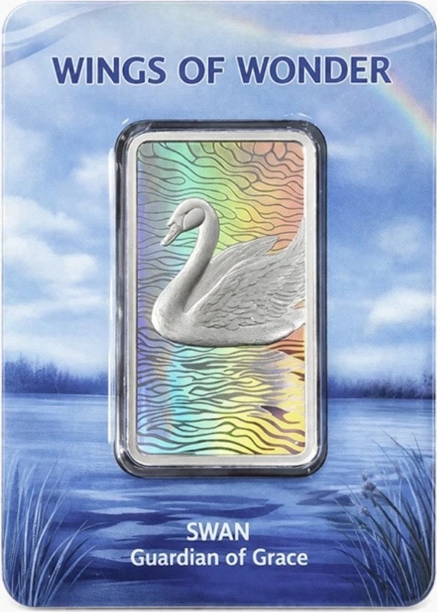 Silver swan figurine on a card with 'Wings of Wonder' branding and a scenic background.