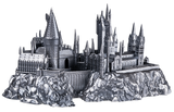 Metallic model of a castle on a rocky base with a white background